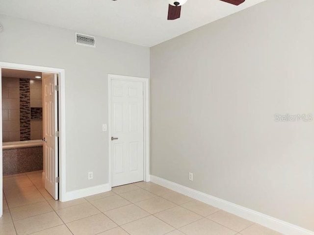 95 Rivers Edge Ln Unit 95, Palm Coast, FL 32137 - unfurnished bedroom featuring light tile patterned floors, baseboards, connected bathroom, and a ceiling fan