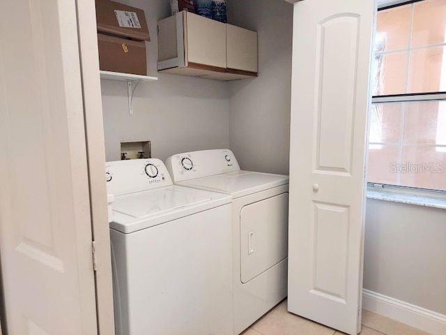 95 Rivers Edge Ln Unit 95, Palm Coast, FL 32137 - washroom featuring washing machine and clothes dryer, cabinet space, light tile patterned floors, and baseboards