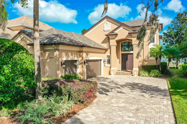 207 S Riverwalk Dr, Palm Coast, FL 32137 - view of front of home featuring stucco siding, an attached garage, and decorative driveway
