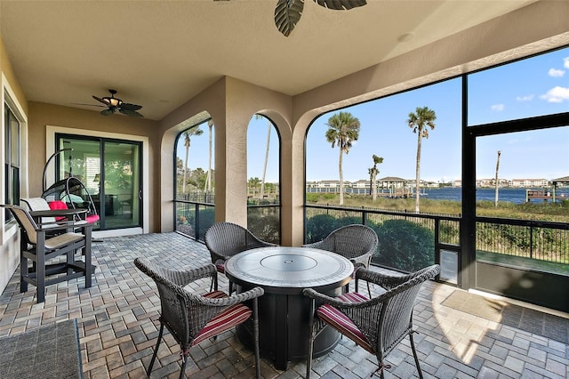 207 S Riverwalk Dr, Palm Coast, FL 32137 - sunroom featuring ceiling fan, a water view, and brick floors