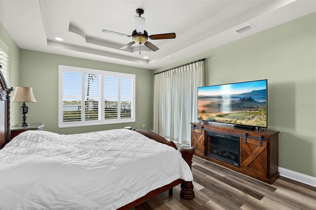 207 S Riverwalk Dr, Palm Coast, FL 32137 - bedroom with a raised ceiling, wood finished floors, ceiling fan, and recessed lighting