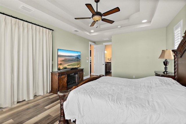 207 S Riverwalk Dr, Palm Coast, FL 32137 - bedroom with a tray ceiling, wood finished floors, recessed lighting, a ceiling fan, and access to exterior