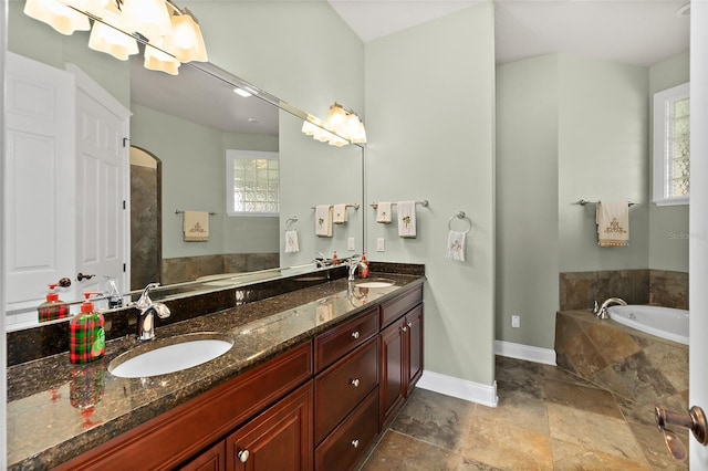207 S Riverwalk Dr, Palm Coast, FL 32137 - full bathroom with a garden tub, plenty of natural light, double vanity, and stone finish floors