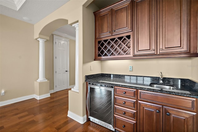 207 S Riverwalk Dr, Palm Coast, FL 32137 - indoor wet bar with wine cooler, decorative columns, dark wood-style floors, and arched walkways