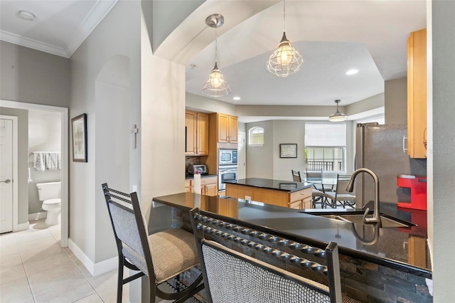 200 Riverfront Dr Unit D302, Palm Coast, FL 32137 - kitchen featuring stainless steel appliances, dark countertops, crown molding, a kitchen island, and light tile patterned floors