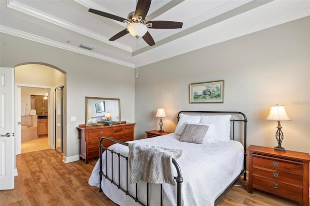 200 Riverfront Dr Unit D302, Palm Coast, FL 32137 - bedroom with arched walkways, wood finished floors, a tray ceiling, crown molding, and ensuite bathroom