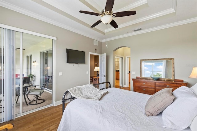 200 Riverfront Dr Unit D302, Palm Coast, FL 32137 - bedroom featuring a raised ceiling, arched walkways, wood finished floors, crown molding, and ceiling fan