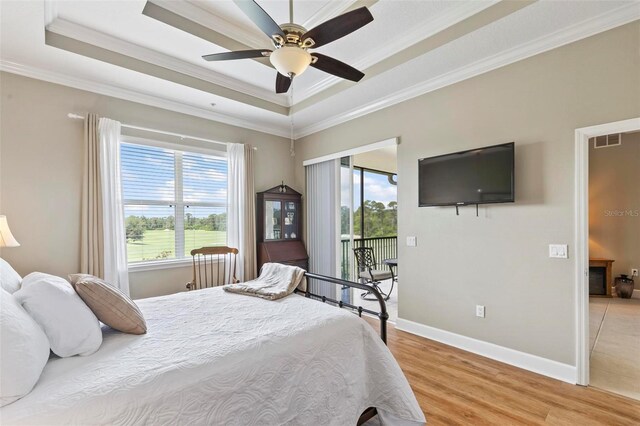 200 Riverfront Dr Unit D302, Palm Coast, FL 32137 - bedroom with multiple windows, a raised ceiling, crown molding, light wood-style flooring, and access to exterior