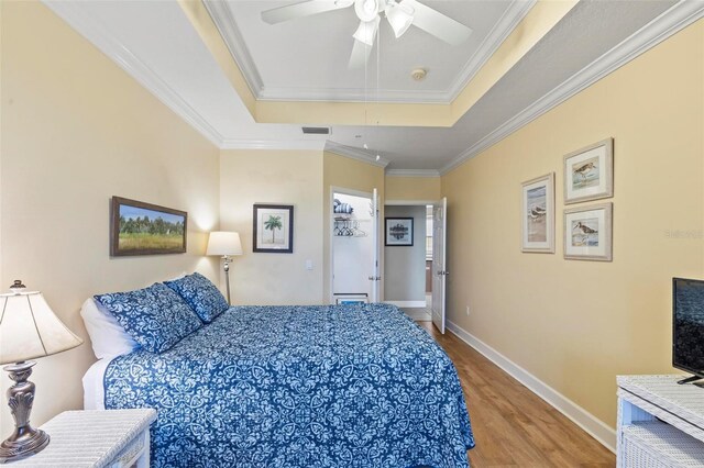 200 Riverfront Dr Unit D302, Palm Coast, FL 32137 - bedroom featuring a tray ceiling, wood finished floors, crown molding, and ceiling fan
