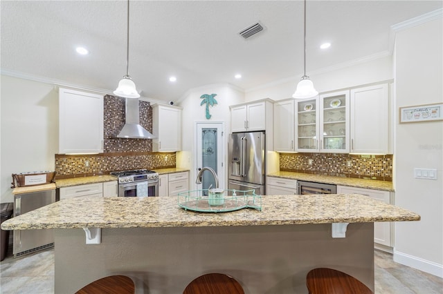 265 Pinehurst Pointe Dr, Saint Augustine, FL 32092 - kitchen featuring appliances with stainless steel finishes, wall chimney range hood, white cabinetry, a breakfast bar, and ornamental molding