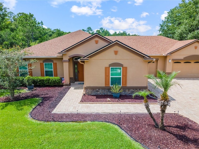 265 Pinehurst Pointe Dr, Saint Augustine, FL 32092 - view of front of home with stucco siding, a front yard, an attached garage, driveway, and a shingled roof