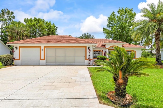 118 Pine Grove Dr, Palm Coast, FL 32164 - mediterranean / spanish-style home featuring an attached garage, concrete driveway, a front lawn, and a tile roof