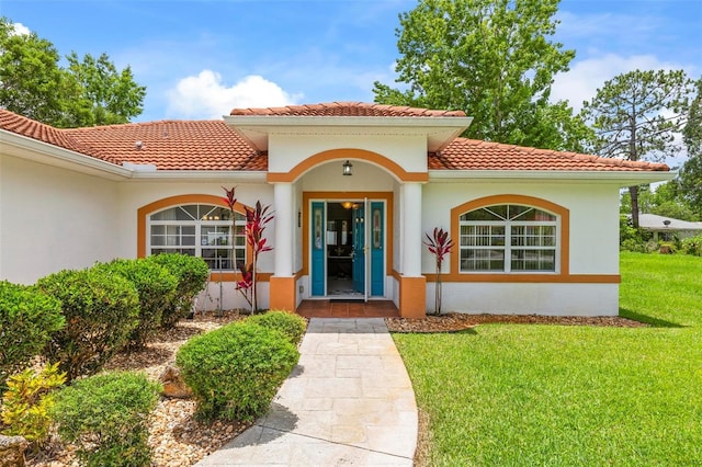 118 Pine Grove Dr, Palm Coast, FL 32164 - entrance to property featuring a tiled roof, a yard, and stucco siding