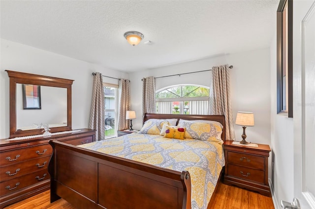 118 Pine Grove Dr, Palm Coast, FL 32164 - bedroom with light wood-style flooring and a textured ceiling
