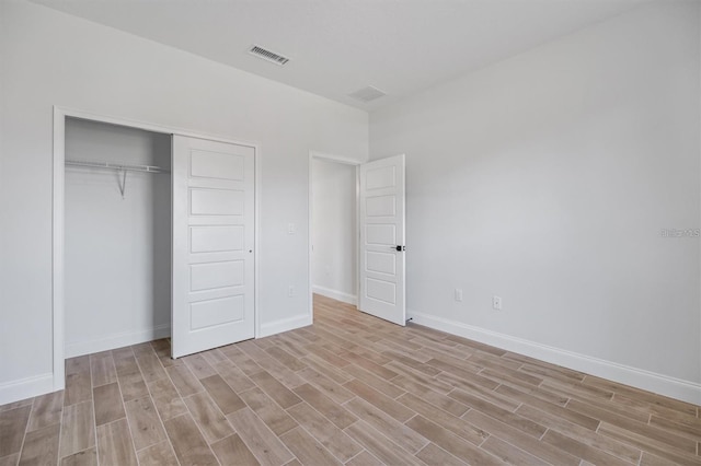 2 Seamanship Trl, Palm Coast, FL 32164 - unfurnished bedroom with light wood-style floors, a closet, and baseboards