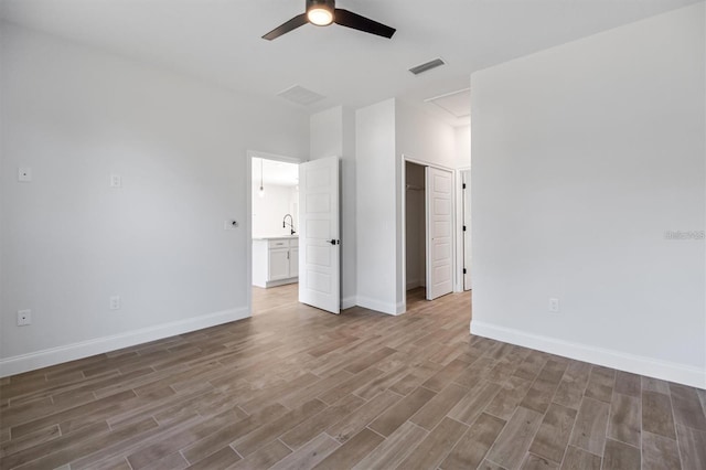 2 Seamanship Trl, Palm Coast, FL 32164 - unfurnished bedroom featuring wood finished floors, attic access, baseboards, a ceiling fan, and a sink