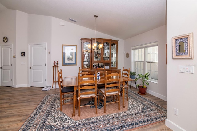 15 Raleigh Dr, Palm Coast, FL 32164 - dining room with lofted ceiling, wood finished floors, and a chandelier