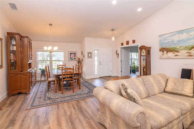 15 Raleigh Dr, Palm Coast, FL 32164 - living room with lofted ceiling, wood finished floors, a chandelier, healthy amount of natural light, and recessed lighting