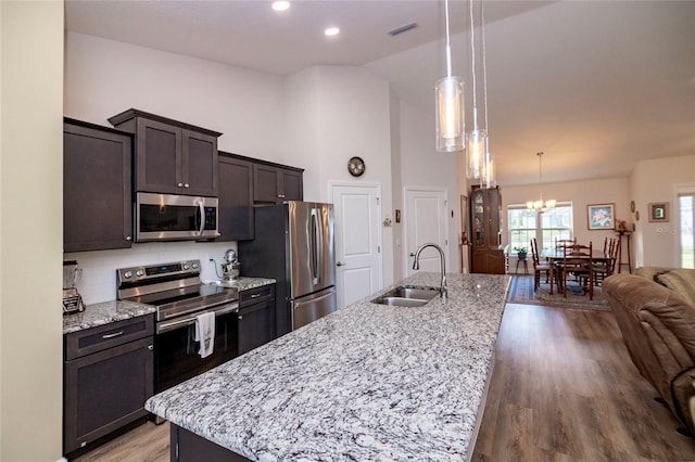 15 Raleigh Dr, Palm Coast, FL 32164 - kitchen with stainless steel appliances, open floor plan, light wood-style flooring, a kitchen island with sink, and dark brown cabinets