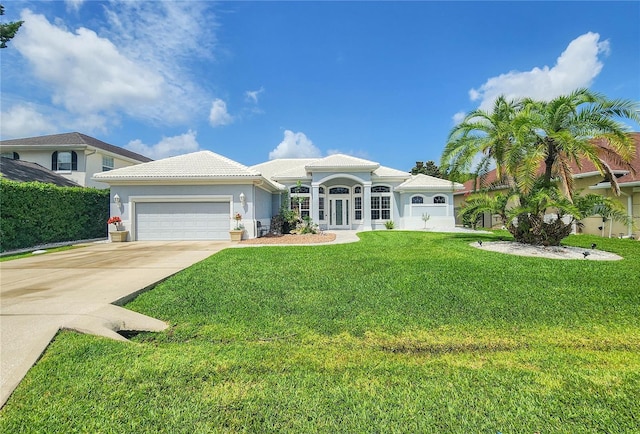 101 Covington Ln, Palm Coast, FL 32137 - mediterranean / spanish-style home featuring an attached garage, driveway, stucco siding, a tiled roof, and a front yard