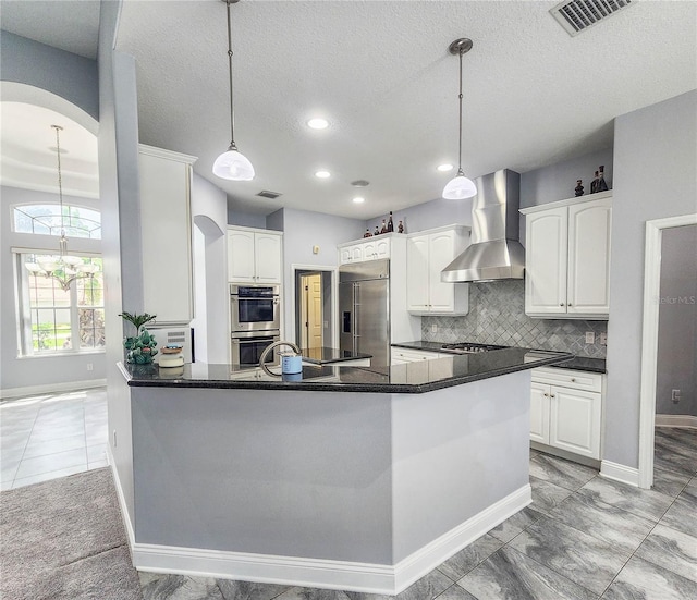 101 Covington Ln, Palm Coast, FL 32137 - kitchen with wall chimney range hood, appliances with stainless steel finishes, arched walkways, white cabinets, and recessed lighting