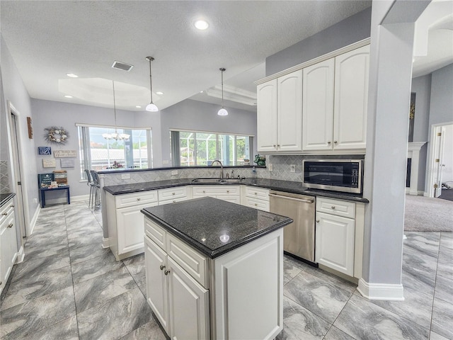 101 Covington Ln, Palm Coast, FL 32137 - kitchen featuring stainless steel appliances, a sink, a chandelier, a peninsula, and healthy amount of natural light