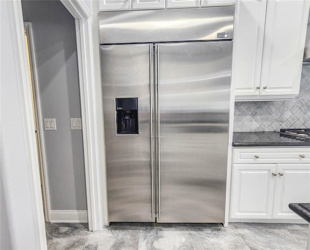 101 Covington Ln, Palm Coast, FL 32137 - kitchen featuring high end fridge, dark countertops, white cabinetry, and backsplash