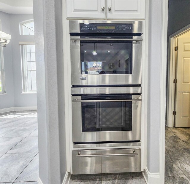 101 Covington Ln, Palm Coast, FL 32137 - kitchen featuring double oven, white cabinetry, baseboards, and a warming drawer