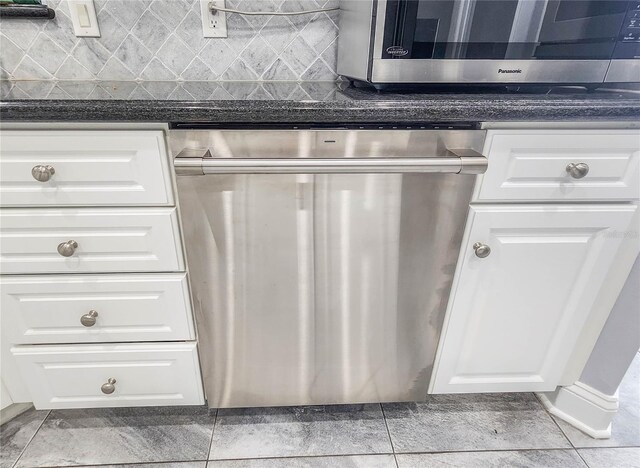 101 Covington Ln, Palm Coast, FL 32137 - kitchen with stainless steel appliances, dark countertops, and white cabinets