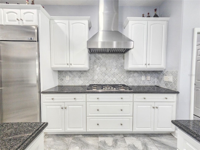 101 Covington Ln, Palm Coast, FL 32137 - kitchen featuring appliances with stainless steel finishes, wall chimney range hood, dark stone countertops, white cabinets, and backsplash