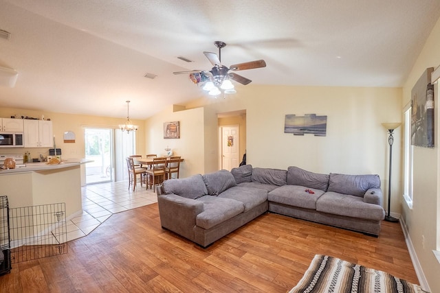 19 Rydell Ln, Palm Coast, FL 32164 - living room featuring ceiling fan, light wood-type flooring, vaulted ceiling, and a chandelier