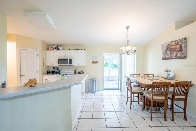 19 Rydell Ln, Palm Coast, FL 32164 - kitchen featuring white electric range oven, a chandelier, white cabinetry, light countertops, and hanging light fixtures