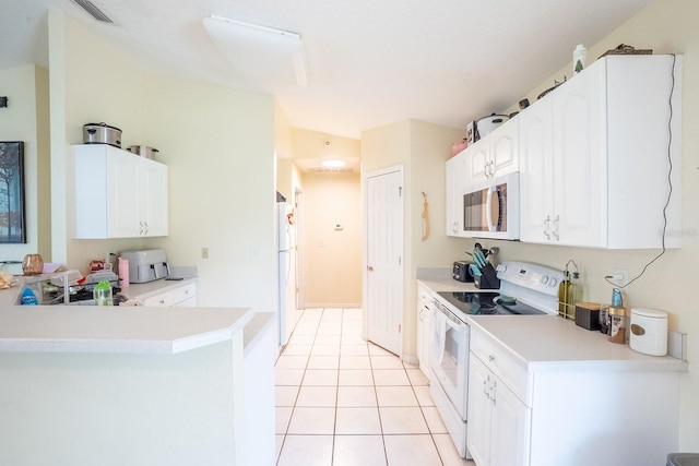 19 Rydell Ln, Palm Coast, FL 32164 - kitchen with white appliances, white cabinets, light tile patterned flooring, light countertops, and a peninsula