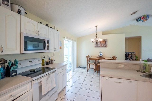 19 Rydell Ln, Palm Coast, FL 32164 - kitchen featuring white appliances, vaulted ceiling, pendant lighting, light tile patterned floors, and a chandelier