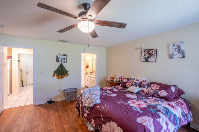 19 Rydell Ln, Palm Coast, FL 32164 - bedroom with light wood-style flooring, a textured ceiling, ceiling fan, and ensuite bathroom