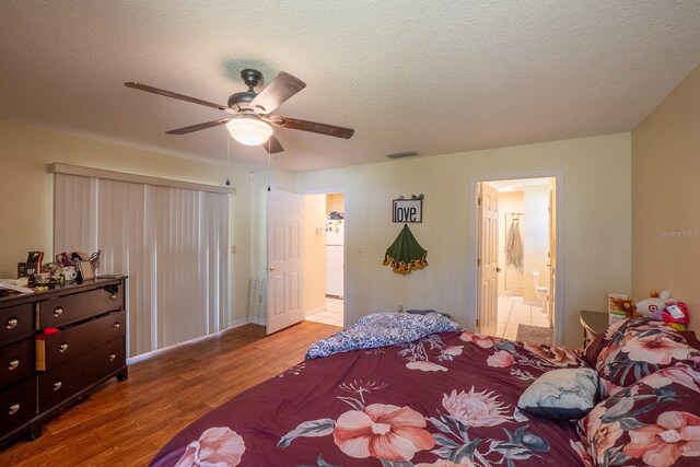 19 Rydell Ln, Palm Coast, FL 32164 - bedroom with wood finished floors, a textured ceiling, a ceiling fan, ensuite bath, and freestanding refrigerator