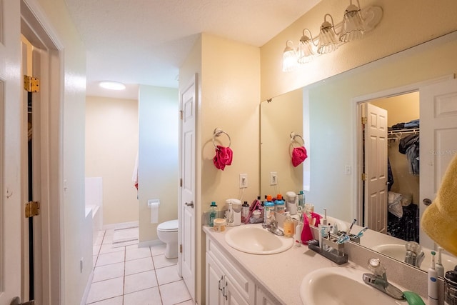 19 Rydell Ln, Palm Coast, FL 32164 - bathroom with tile patterned floors, double vanity, a tub to relax in, and a walk in closet
