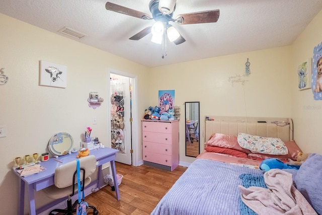 19 Rydell Ln, Palm Coast, FL 32164 - bedroom featuring light wood-style floors, a ceiling fan, a textured ceiling, and a spacious closet