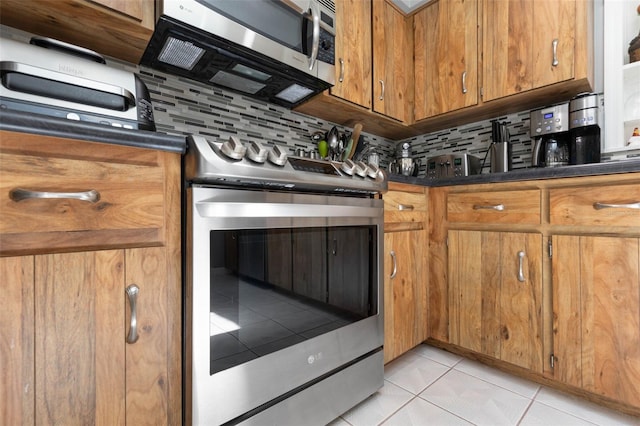 12 Fernwood Ln, Palm Coast, FL 32137 - kitchen with stainless steel appliances, dark countertops, decorative backsplash, and brown cabinetry