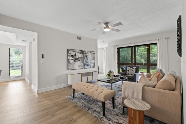 7 Sherbury Ct Unit 7, Palm Coast, FL 32137 - living room featuring ceiling fan, light wood-style floors, baseboards, and a textured ceiling