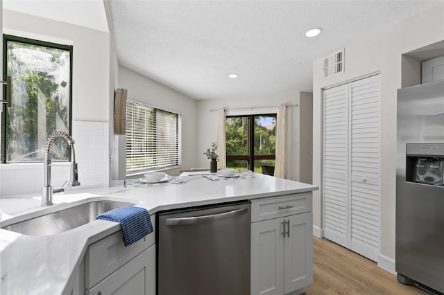 7 Sherbury Ct Unit 7, Palm Coast, FL 32137 - kitchen with appliances with stainless steel finishes, a sink, light wood-style flooring, a peninsula, and recessed lighting
