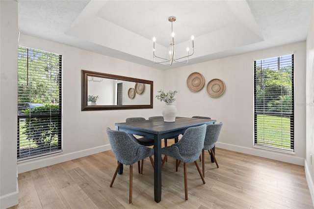 7 Sherbury Ct Unit 7, Palm Coast, FL 32137 - dining space with a raised ceiling, a chandelier, light wood finished floors, and baseboards
