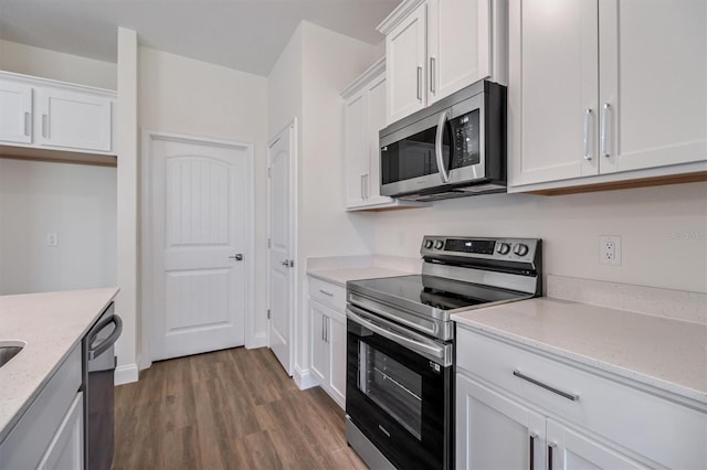 52 Pershing Ln, Palm Coast, FL 32164 - kitchen with stainless steel appliances, dark wood-type flooring, white cabinets, and light stone countertops
