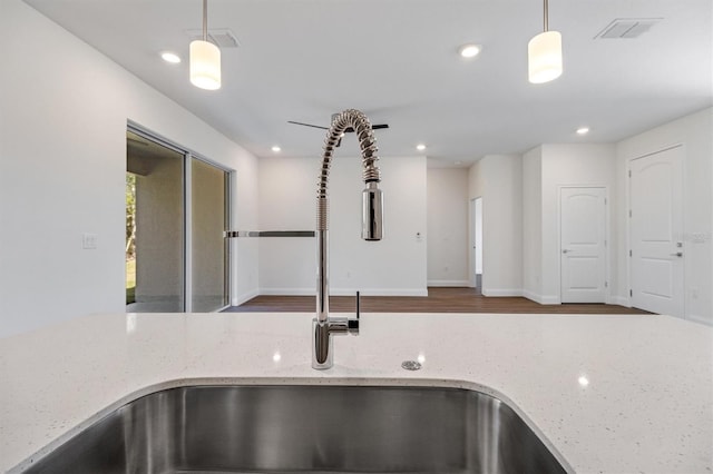 52 Pershing Ln, Palm Coast, FL 32164 - kitchen view of pendant lighting, recessed lighting, light stone counters, and wood finished floors