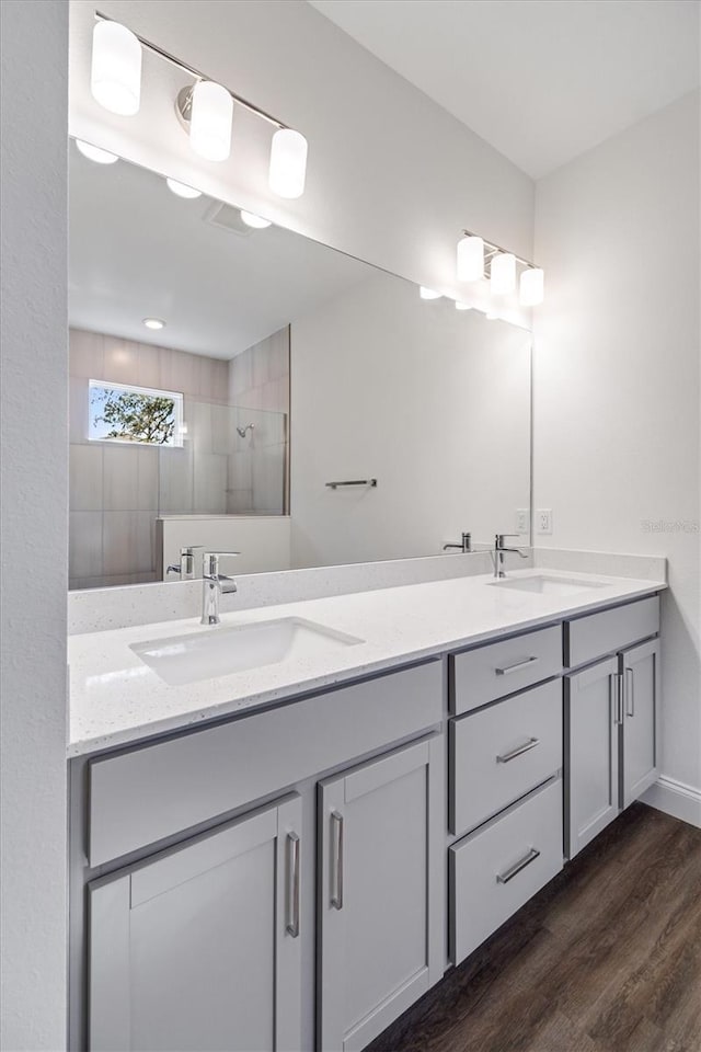 52 Pershing Ln, Palm Coast, FL 32164 - bathroom with double vanity, wood finished floors, and tiled shower