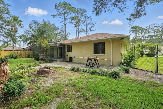 131 Boulder Rock Dr, Palm Coast, FL 32137 - back of house featuring a fire pit, a sunroom, stucco siding, and a patio area
