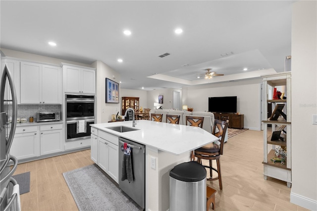 2137 Raglan Cir, Ormond Beach, FL 32174 - kitchen featuring appliances with stainless steel finishes, a breakfast bar, open floor plan, recessed lighting, and white cabinetry