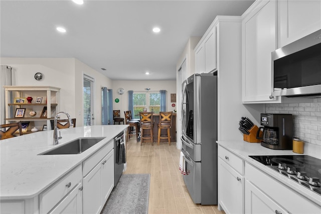 2137 Raglan Cir, Ormond Beach, FL 32174 - kitchen featuring appliances with stainless steel finishes, recessed lighting, white cabinetry, backsplash, and light stone countertops