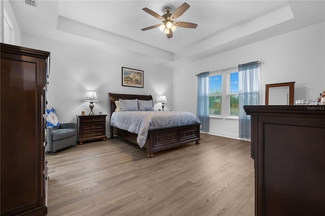 2137 Raglan Cir, Ormond Beach, FL 32174 - bedroom with a raised ceiling, light wood-style flooring, and a ceiling fan