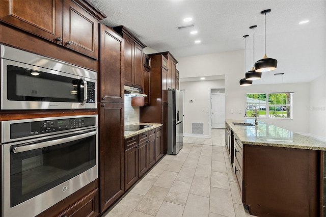 7 Zeolite Pl, Palm Coast, FL 32164 - kitchen featuring stainless steel appliances, under cabinet range hood, dark brown cabinetry, decorative light fixtures, and recessed lighting